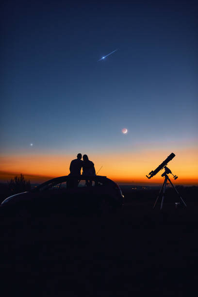 istock Couple stargazing together with a astronomical telescope. 1345638637