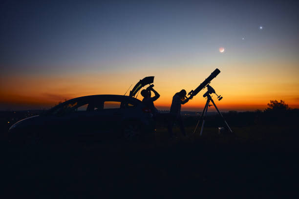 istock Couple stargazing together with a astronomical telescope. 1345638722