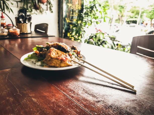 Have a break. Vegetarian food can be delicious for everybody. Fried soy meat with rice and stew vegetables in white plate with chopsticks in simple asian vegan cafe. Healthy eating, caring for animals