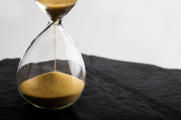 istock Sand clock , Hourglass as time passing on black slate background , Life time concept 1345639866