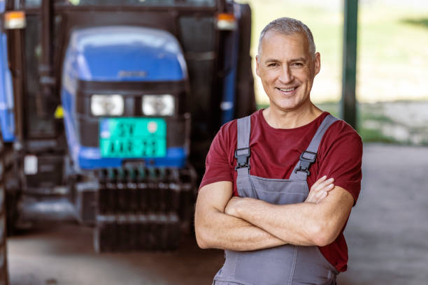 man posing in rural tractors warehouse - photography gray hair farmer professional occupation imagens e fotografias de stock