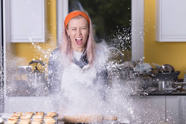 Baking disaster Young lady in a messy kitchen disaster. flour mess stock pictures, royalty-free photos & images