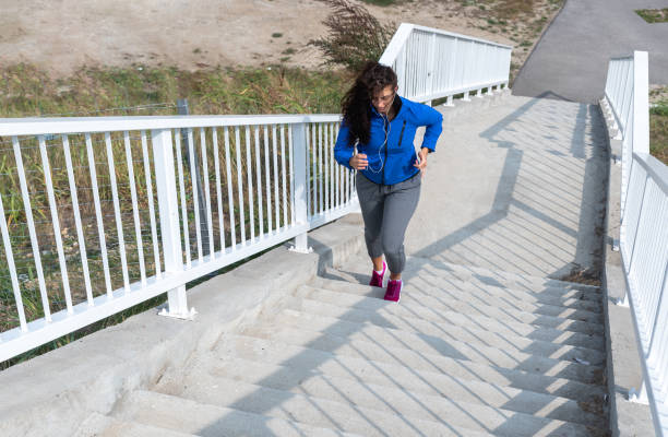 молодая активная женщина бегает по лестнице в спортивном гардеробе, тренируется для здоровой жизни и готовит себя к марафону. - starting line running sprinting alertness стоковые фото и изображения