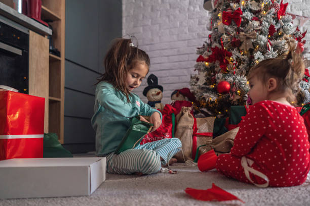 istock During Christmas morning, joyful sisters unpacking their Christmas presents 1345644597
