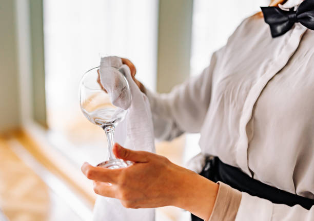 La fille serveur nettoie le verre de vin. - Photo