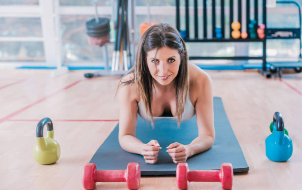 istock long haired blonde girl performing a floor plank looking at camera. 1345647715