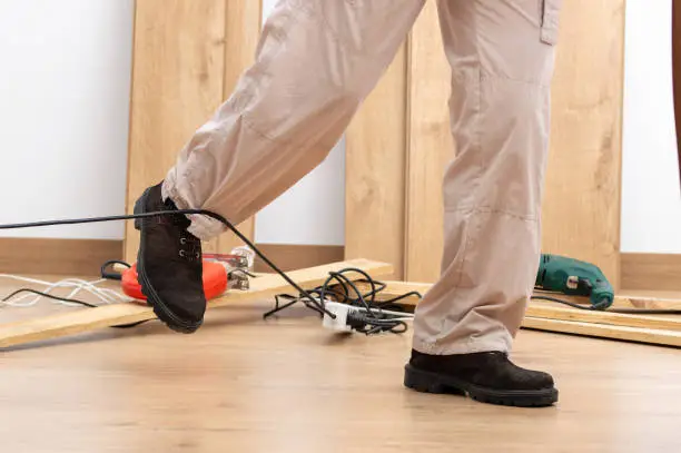 Photo of carpenter legs stumbling with an electrical cord