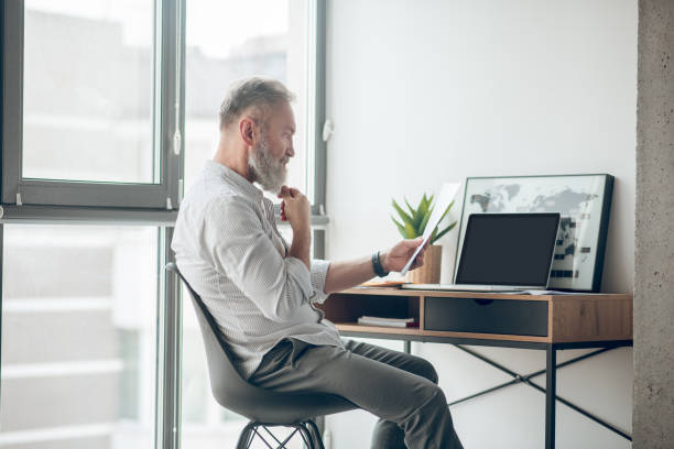 istock A midaged businessman holding papers and ecrutinizing them 1345648906