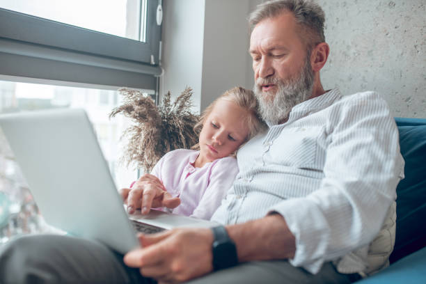 istock A man working while his little daughter sitting next to him 1345648958