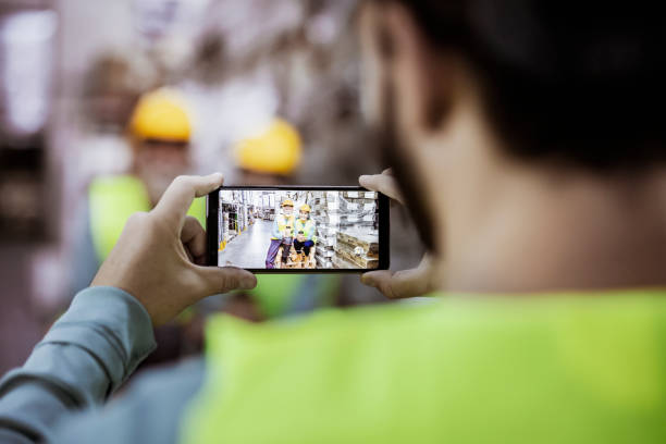 Unrecognizable Man Photographing His Warehouse Colleagues