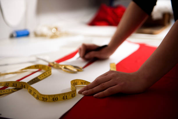 istock Young dressmaker woman sews clothes on sewing machine. 1345651150