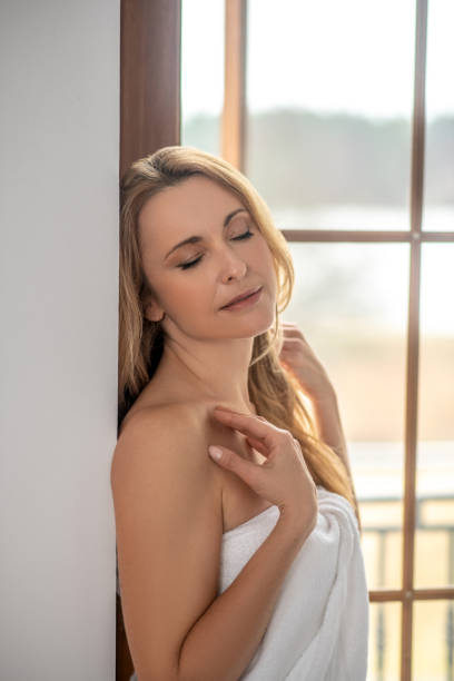 istock Blonde woman with closed eyes and bare shoulders 1345651340