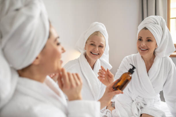 istock Three girlfriends with pleasure trying new cosmetic product 1345651361