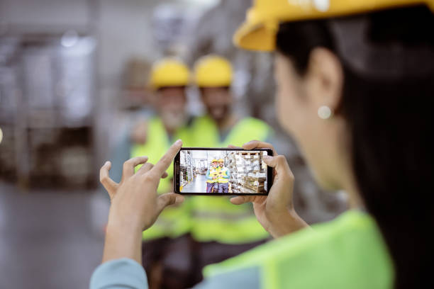 istock Unrecognizable Woman Photographing Her Warehouse Colleagues 1345651749