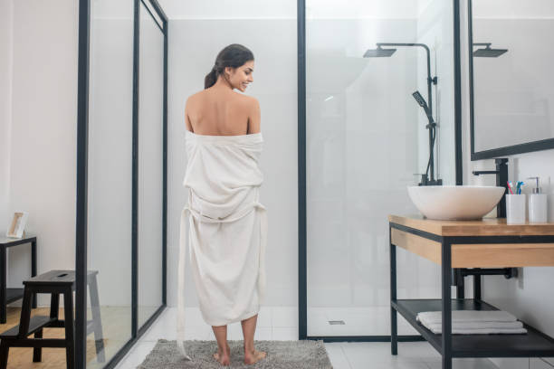 istock A dark-haired young girl in a white bathrobe in the bathroom 1345652614