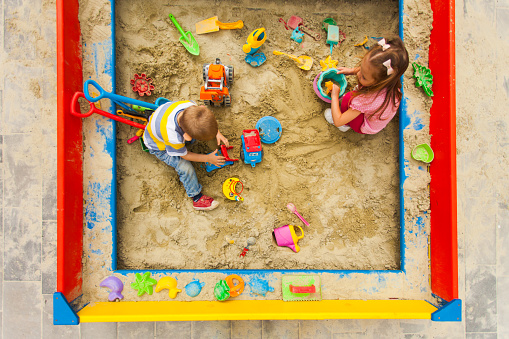 Little boy playing in the sandbox on a farm