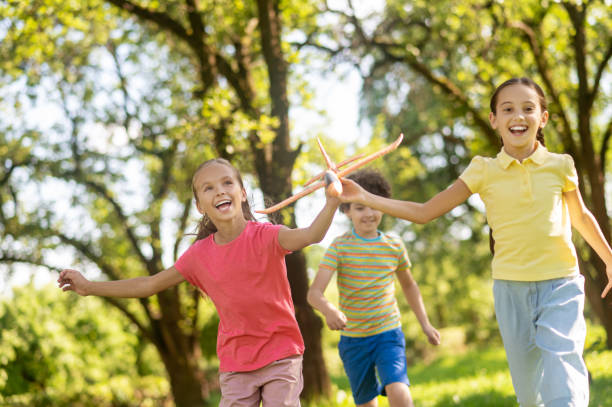 istock Running two joyful girls with toy and boy 1345656343