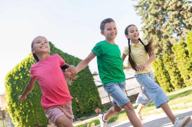 istock Boy and two girls running in park 1345656387