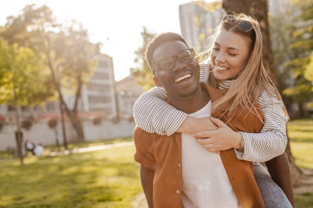 istock Interracial couple piggybacking outdoors 1345658734