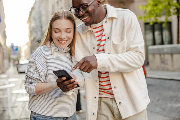 istock Friends walking and using mobile phone on the move 1345658790