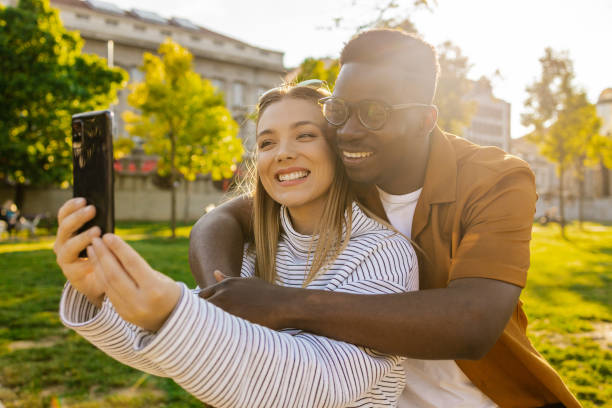 istock Interracial couple embracing outdoors and using mobile phone 1345658825