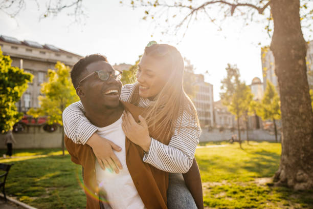 istock Interracial couple piggybacking outdoors 1345659062