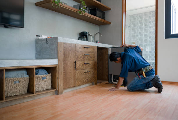 Plumber installing a dishwasher at a house