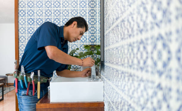 Plumber installing a faucet in a bathroom's sink Latin American Plumber fixing a leak in a faucet in a bathroom's sink - home repairment concepts plumber stock pictures, royalty-free photos & images