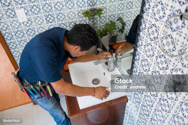 Plumber Installing A Faucet In A Bathrooms Sink Stock Photo - Download Image Now - Bathroom, Renovation, Home Addition