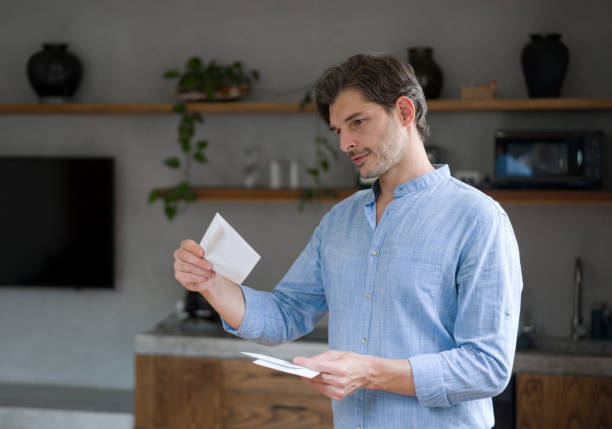 自宅でハッピーマンがメールで手紙をチェック - opening mail letter envelope ストックフォトと画像