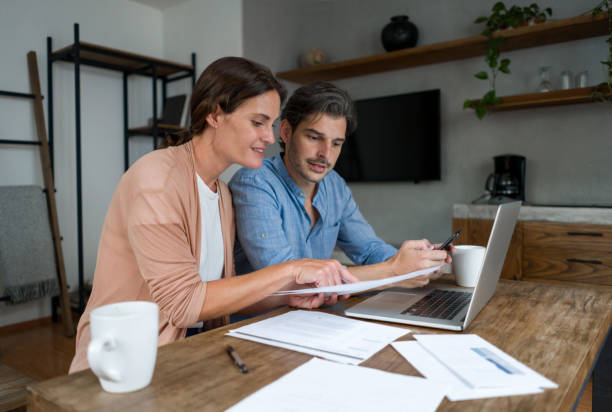 istock Loving couple at home paying bills online 1345670598
