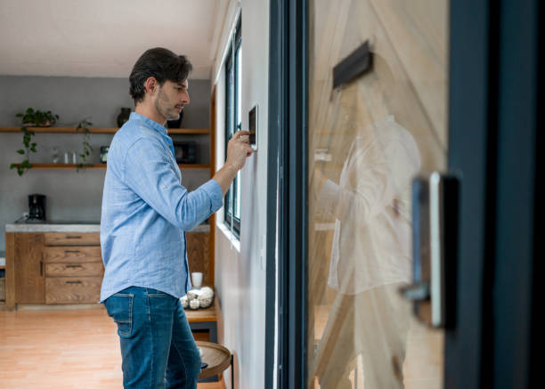 istock Man locking the door of his house with an automated security system 1345670619