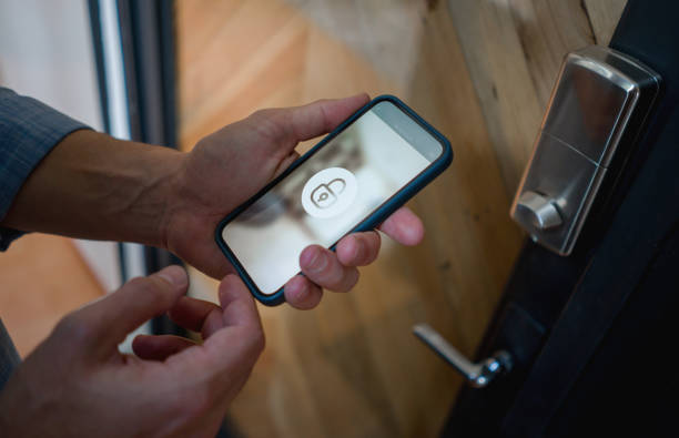 man opening the door of his house using a home automation system - lock imagens e fotografias de stock