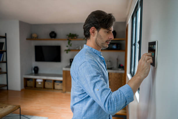 istock Man leaving his house and locking the door with an automated security system 1345670626