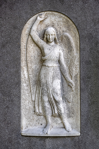 Figure of a female angel on a anonymous tombstone in a church yard in Helsingør north of Copenhagen
