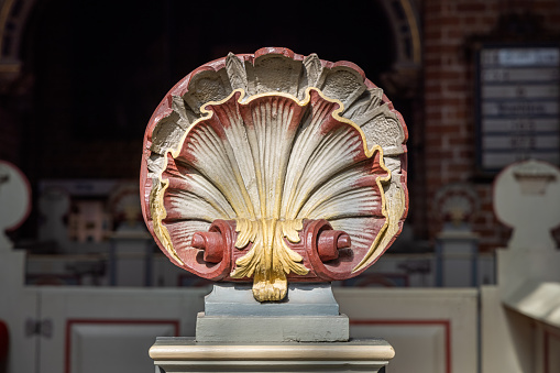 Ornament formed as a seashell on the end of a pew in Sankt Mariæ Kirke – The Church of Our Lady – is part of a former Carmelite Priory and the church is from 1430. Today it is a normal Danish church in Helsingør also known as Elsinore in English.