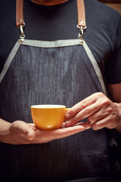Barista holding and serving cup of fresh coffee
