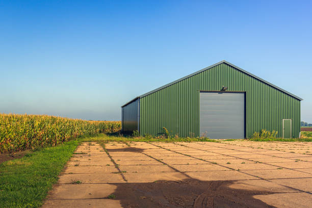 moderne landwirtschaftliche scheune mit einem garten aus betonplatten - scheune stock-fotos und bilder