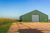 istock Modern agricultural barn with a yard of concrete slabs 1345675397