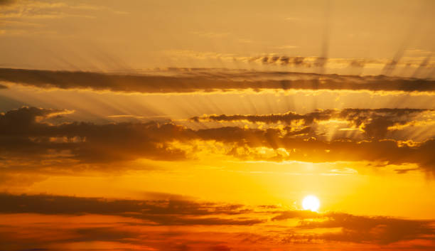 istock Sunbeams breaking through the dark clouds at sunset. Only sky, no land. 1345675992