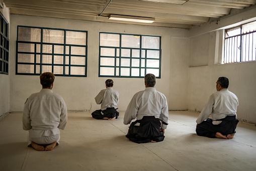 Four men sitting in the gym. They are doing concertation exercise