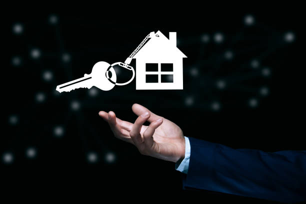 man holding house key icon on dark background
