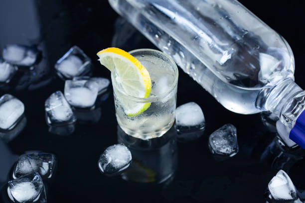 istock bottle of vodka and glass with lemon 1345680011