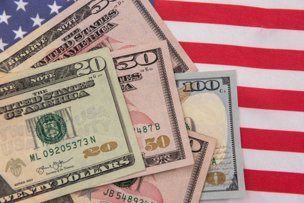 istock banknotes of various denominations on  American flag 1345681396