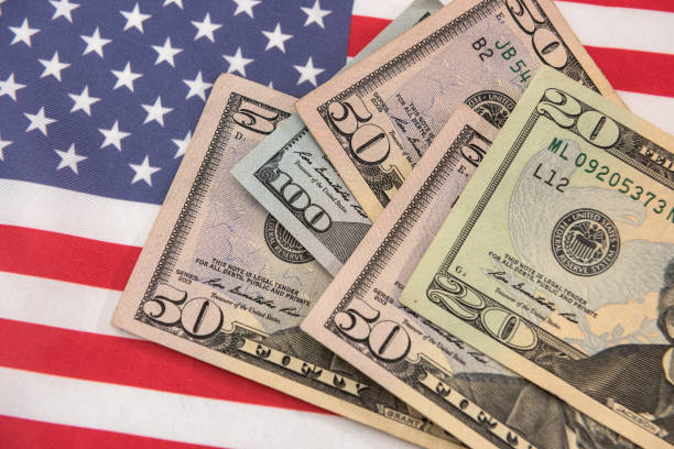 istock banknotes of various denominations on  American flag 1345681610