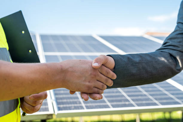 istock Male handshakes close up against solar panels . 1345682932