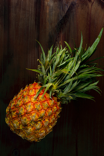 High angle view of pineapple fruit over wood table in the kitchen.Image made with a full frame 24 megapixels camera and 50 mm f/stop 1.4 lens