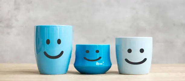 Photo of World smile day and International coffee day concept. happy face of blue coffee cup for customer review. Service rating, ranking, satisfaction and feedback