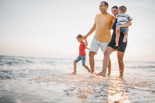 istock Family walking on the beach 1345687488