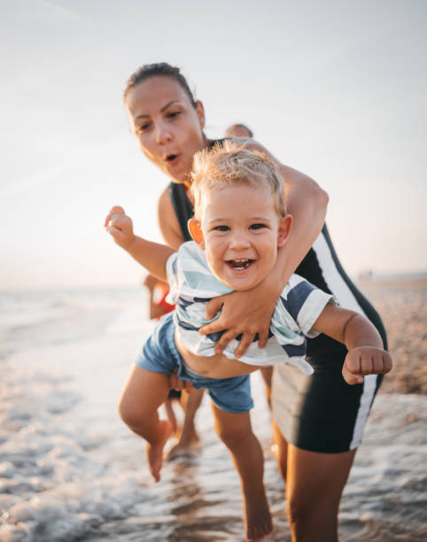 istock Mom is playing with her son on the beach 1345688211